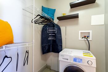 a laundry room with a washing machine and a jacket on a rack at 500 Fifth Apartments, Tennessee